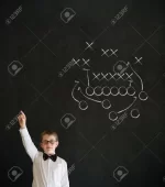 19727496-Hand-up-answer-boy-dressed-up-as-business-man-with-chalk-American-football-strategy-...webp